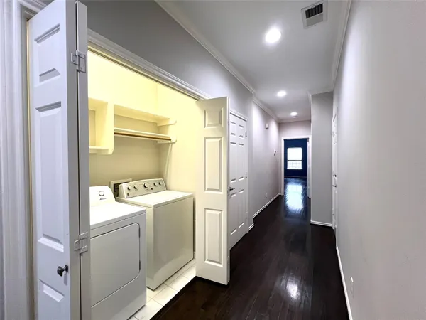 an empty room with wooden floor chandelier fan and windows