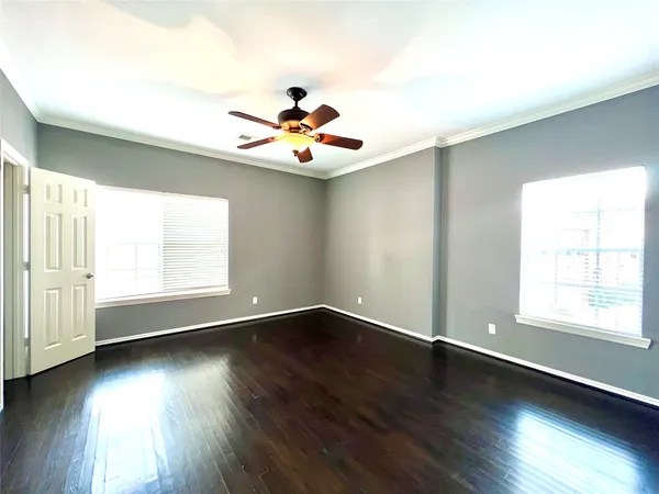 a view of a hallway with wooden floor and a ceiling fan