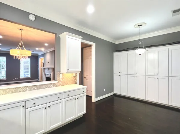 a large white kitchen with a large window appliances and cabinets