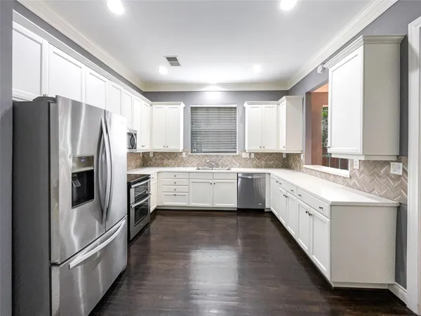 a kitchen with white cabinets and white appliances