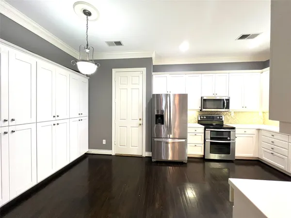 a kitchen with stainless steel appliances a refrigerator and a stove top oven