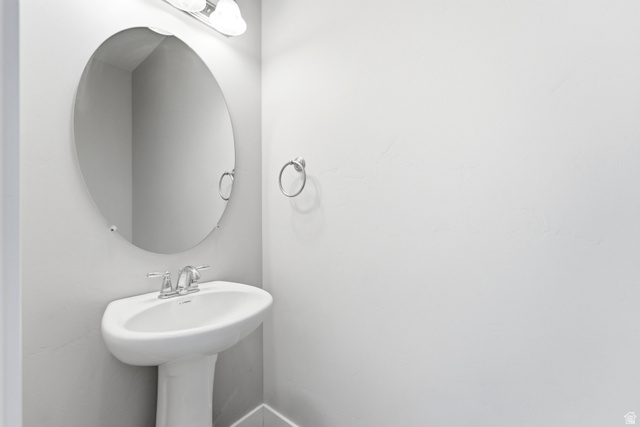 1614 Aspen Loop Provo, UT 84606 - Photo 6 of 47 Pedestal sink with chrome faucet, complemented by an oval wall-mounted mirror