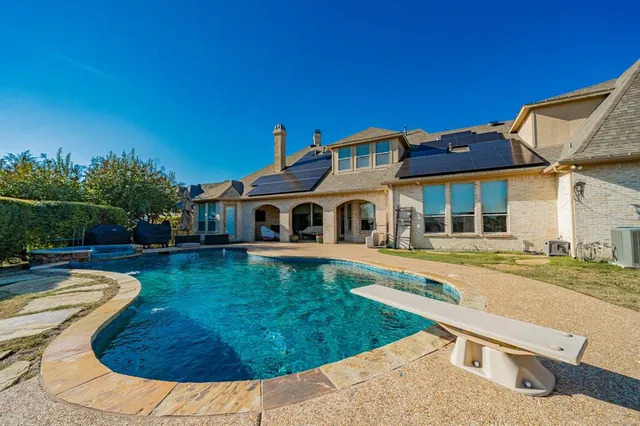 a view of a house with swimming pool and a yard