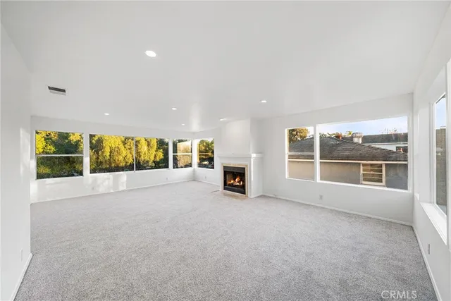a view of an empty room with a fireplace and a large window
