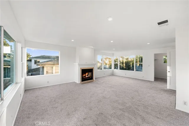 an empty room with fireplace and windows