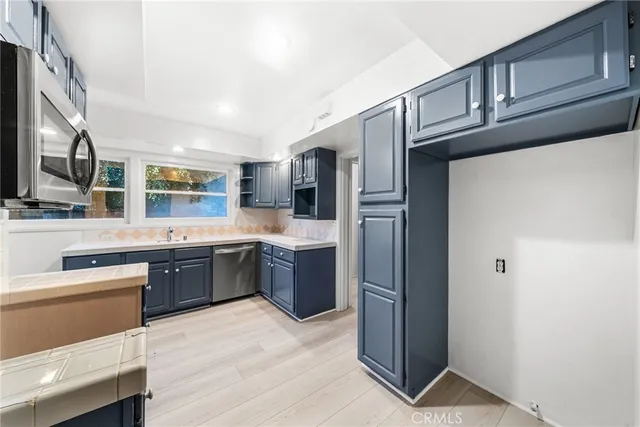 a kitchen with stainless steel appliances kitchen island granite countertop a refrigerator stove and sink