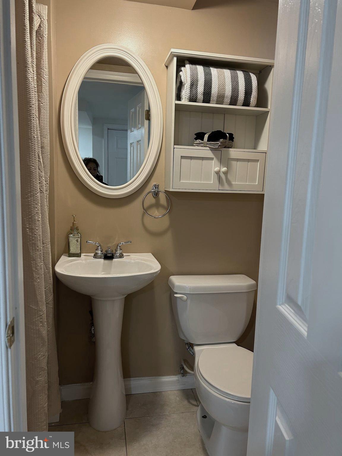 603 Braeside Road Baltimore, MD 21229 - Photo 24 of 30 a bathroom with a toilet sink and mirror