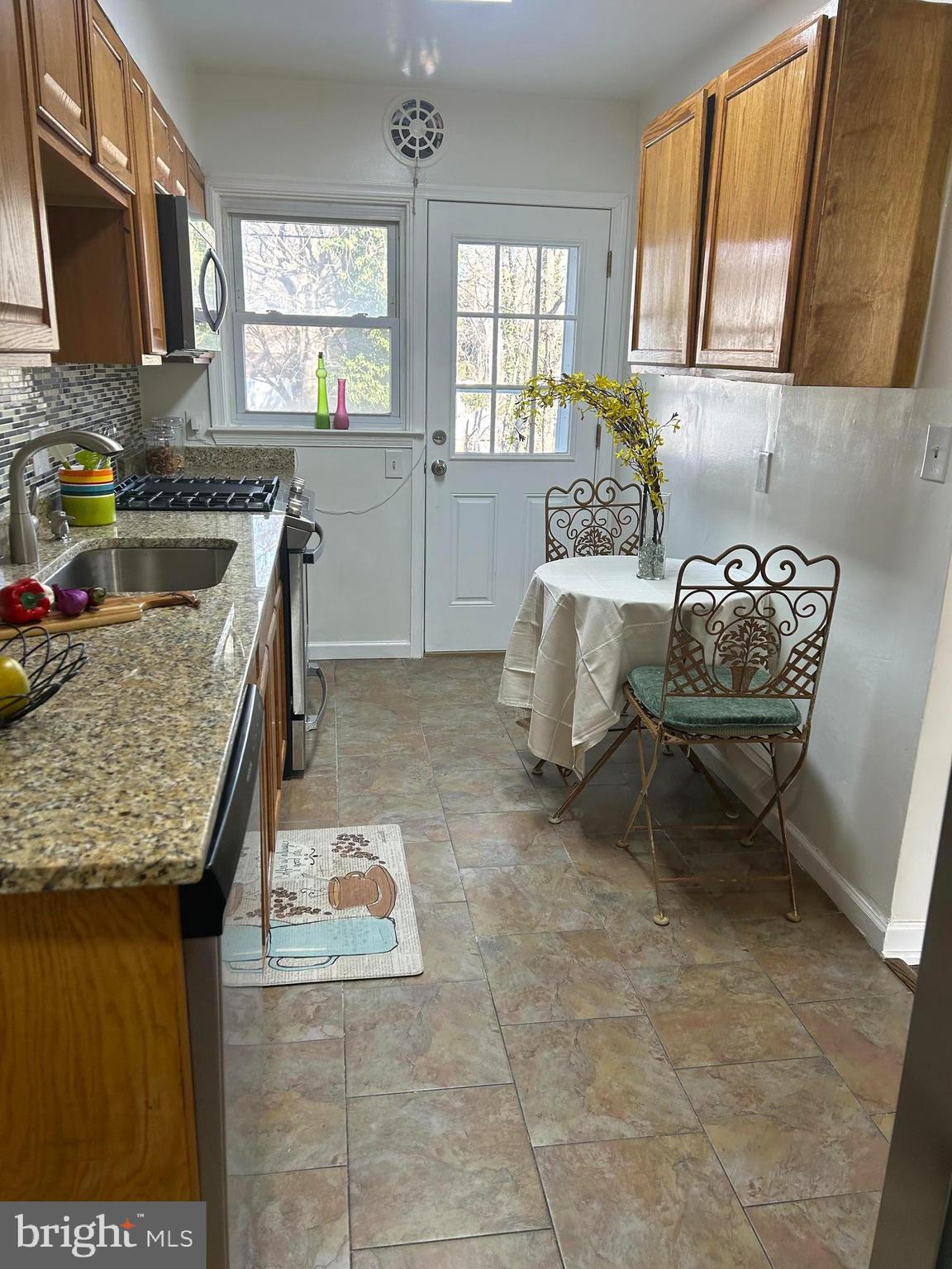 603 Braeside Road Baltimore, MD 21229 - Photo 9 of 30 a kitchen with a stove a sink and a microwave