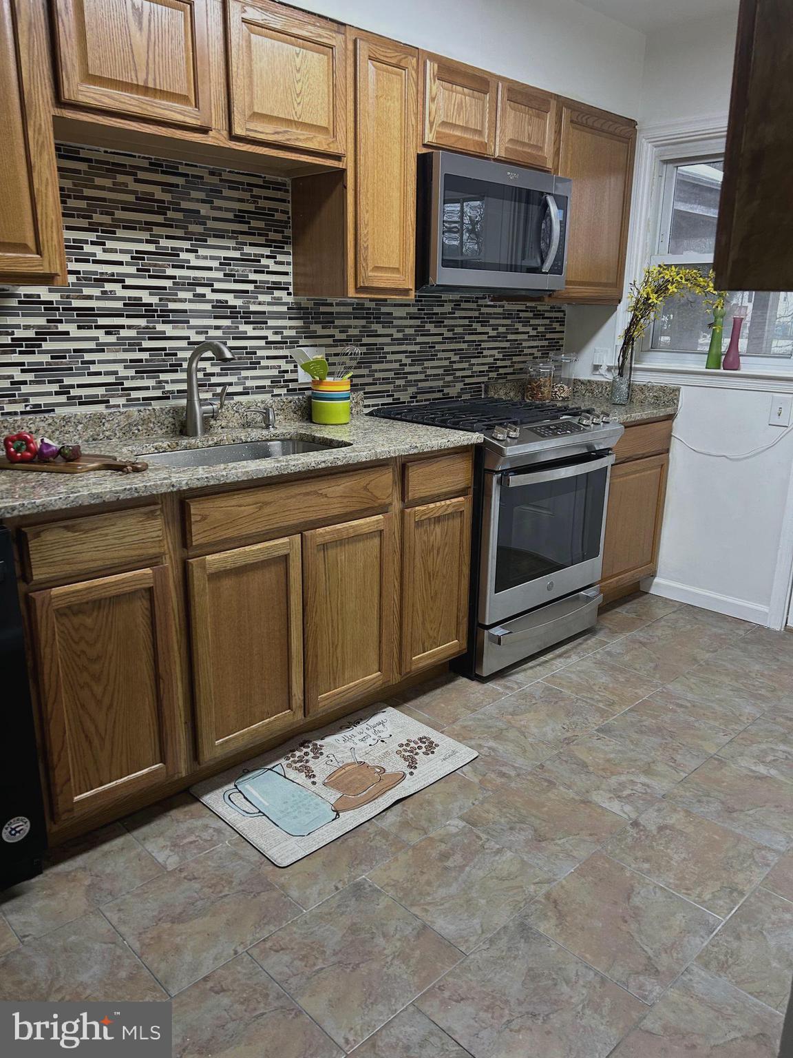 603 Braeside Road Baltimore, MD 21229 - Photo 10 of 30 a kitchen with stainless steel appliances granite countertop a stove a sink and a microwave