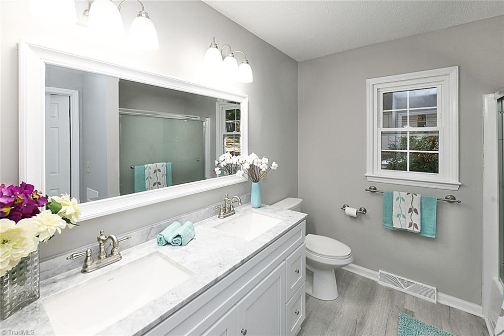 3390 Wide Country Road Pfafftown, NC 27040 - Photo 24 of 50 Main level hall bathroom with double sinks, granite counter, tub/shower combo with new glass doors.