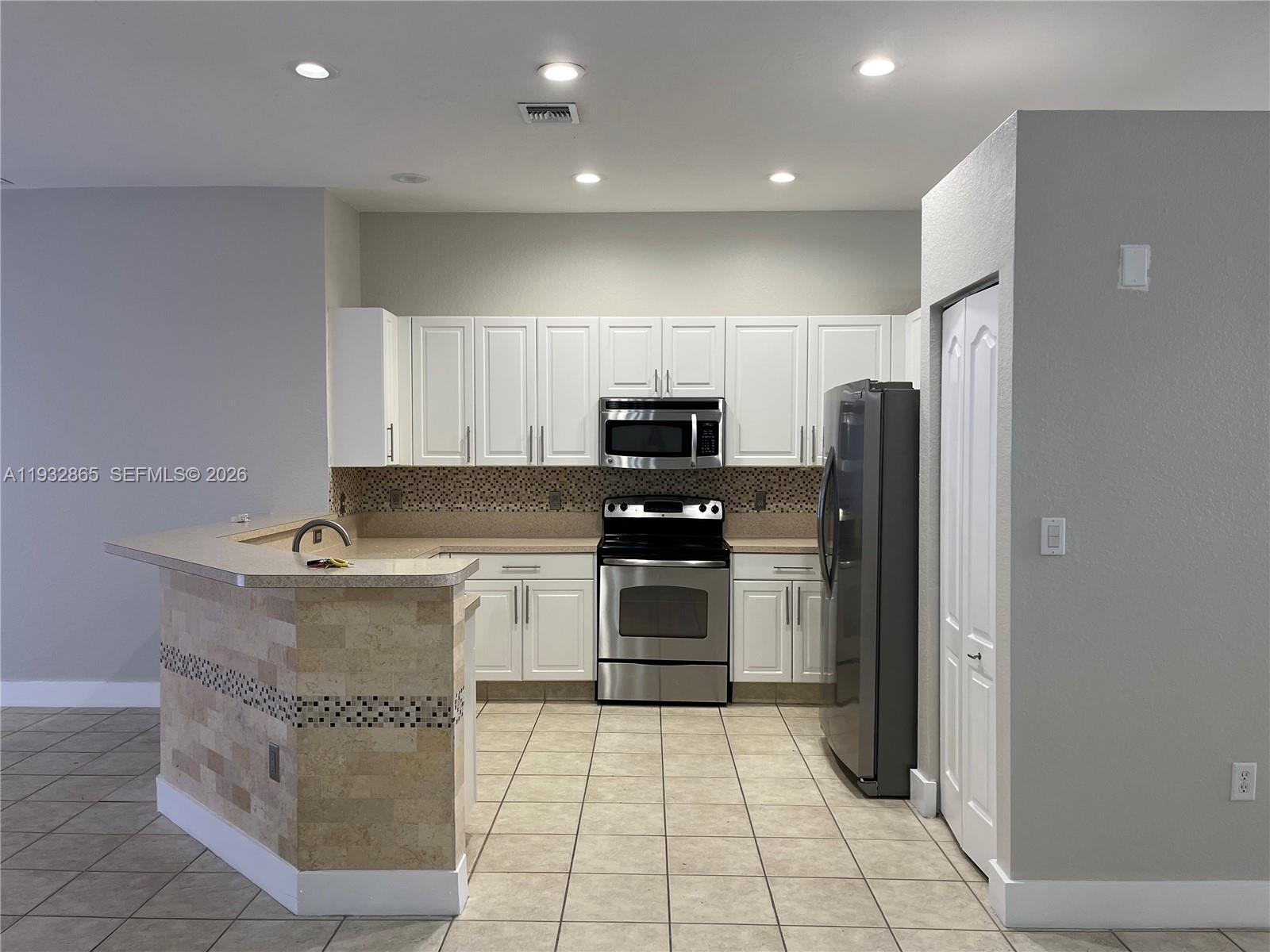 15205 Southwest 13th Terrace Miami, FL 33194 - Photo 8 of 12 a kitchen with stainless steel appliances granite countertop a refrigerator and a stove top oven