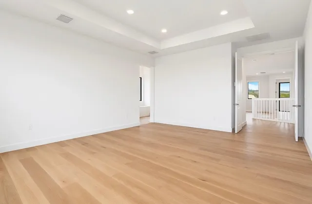 a view of an empty room with wooden floor