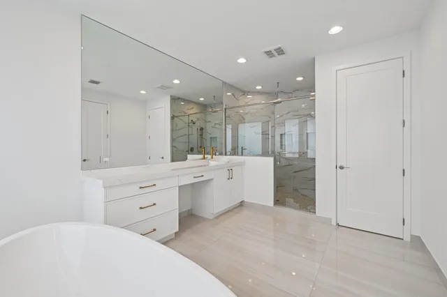 a bathroom with a double vanity sink mirror and shower