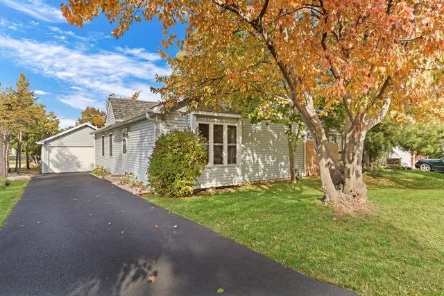 a view of a house with a big yard and large tree
