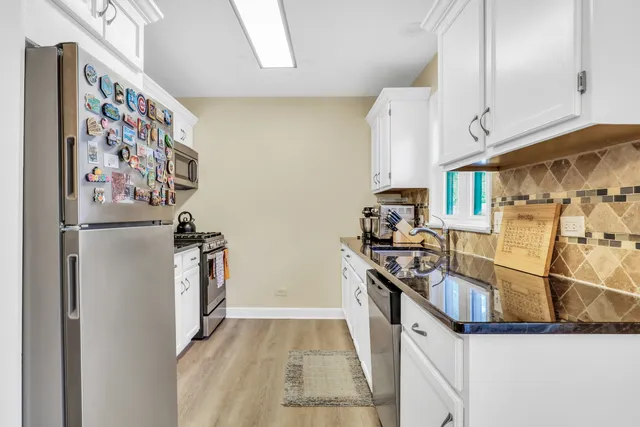 a kitchen with stainless steel appliances granite countertop a refrigerator and a stove