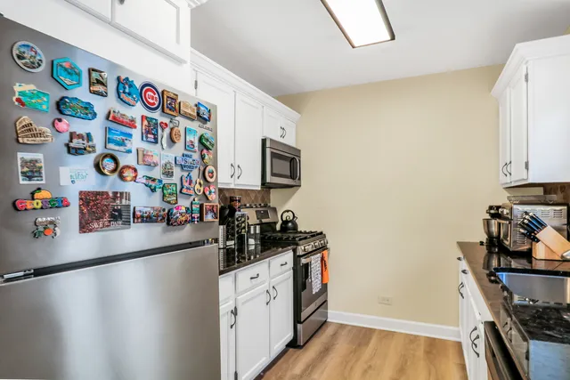 a kitchen with stainless steel appliances a microwave a sink and a refrigerator