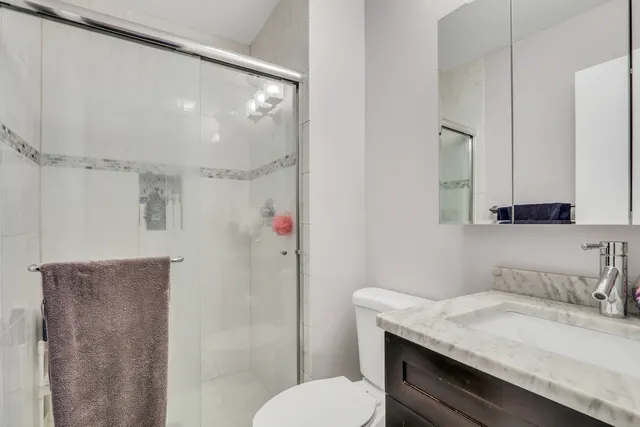 a bathroom with a granite countertop sink toilet and shower