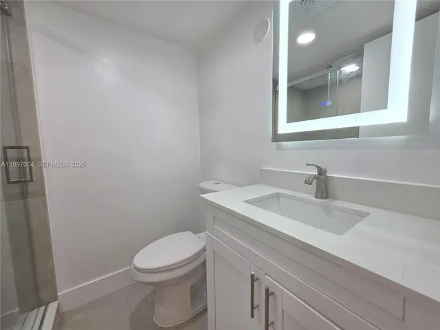 a bathroom with a sink a toilet and mirror