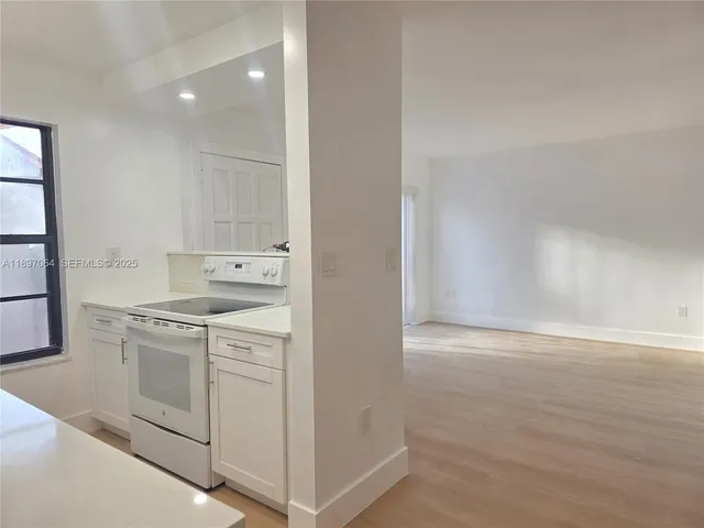 a kitchen with white cabinets and white appliances