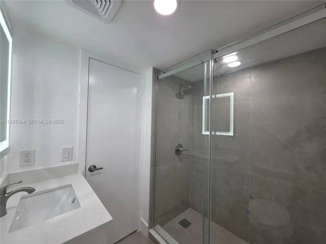 a bathroom with a shower and a sink