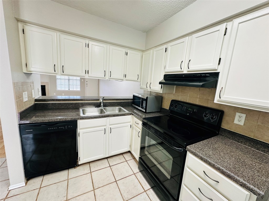 2215 Post Road, Unit 2028 Austin, TX 78704 - Photo 2 of 25 a kitchen with a stove and white cabinets