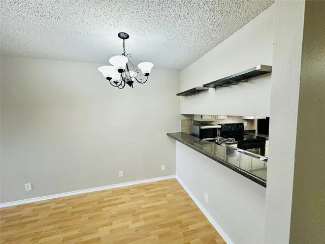 a kitchen with granite countertop white cabinets and stainless steel appliances