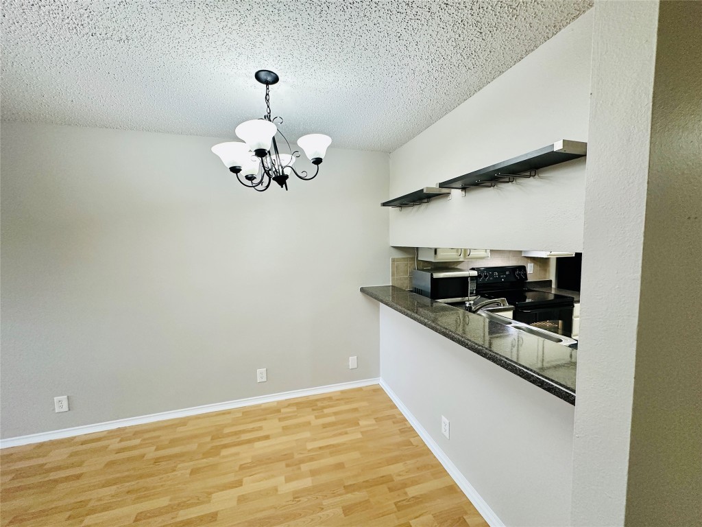 2215 Post Road, Unit 2028 Austin, TX 78704 - Photo 7 of 25 a kitchen with granite countertop white cabinets and stainless steel appliances
