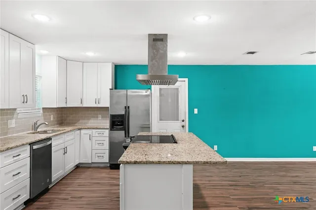 a kitchen with a sink dishwasher and a stove with wooden floor