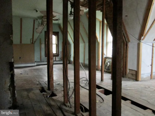 a view of walk in closet with window and hardwood