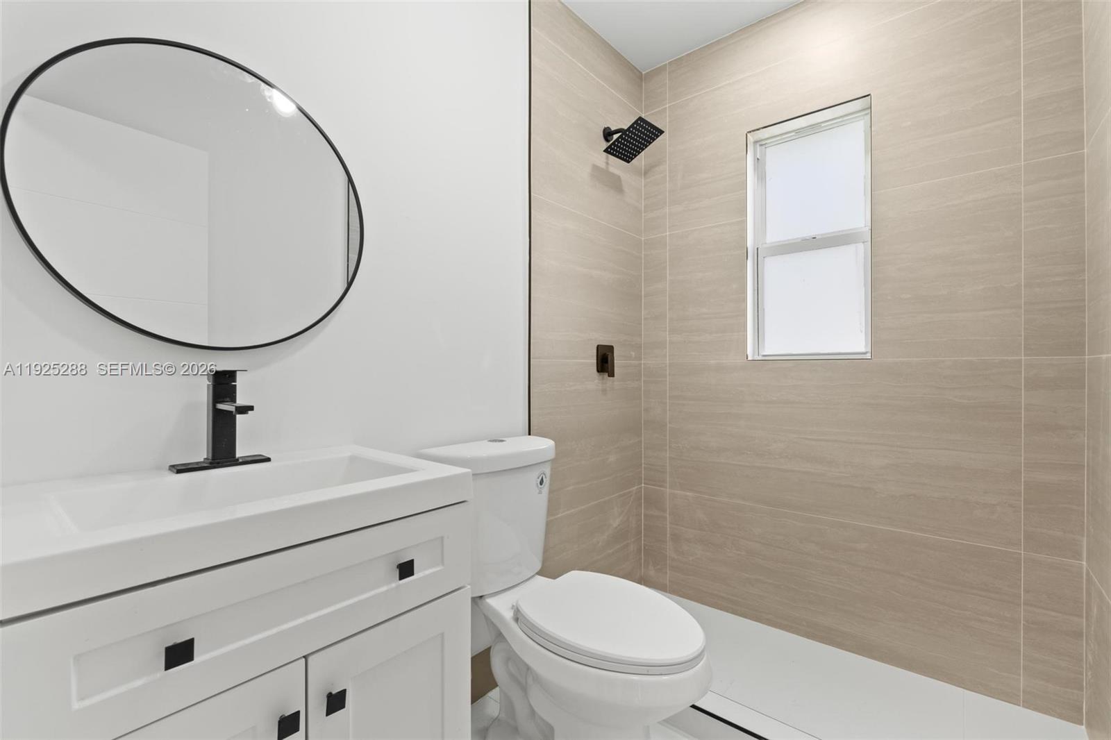 1453 Northwest 56th Street Miami, FL 33142 - Photo 11 of 29 a bathroom with a sink a toilet and a mirror