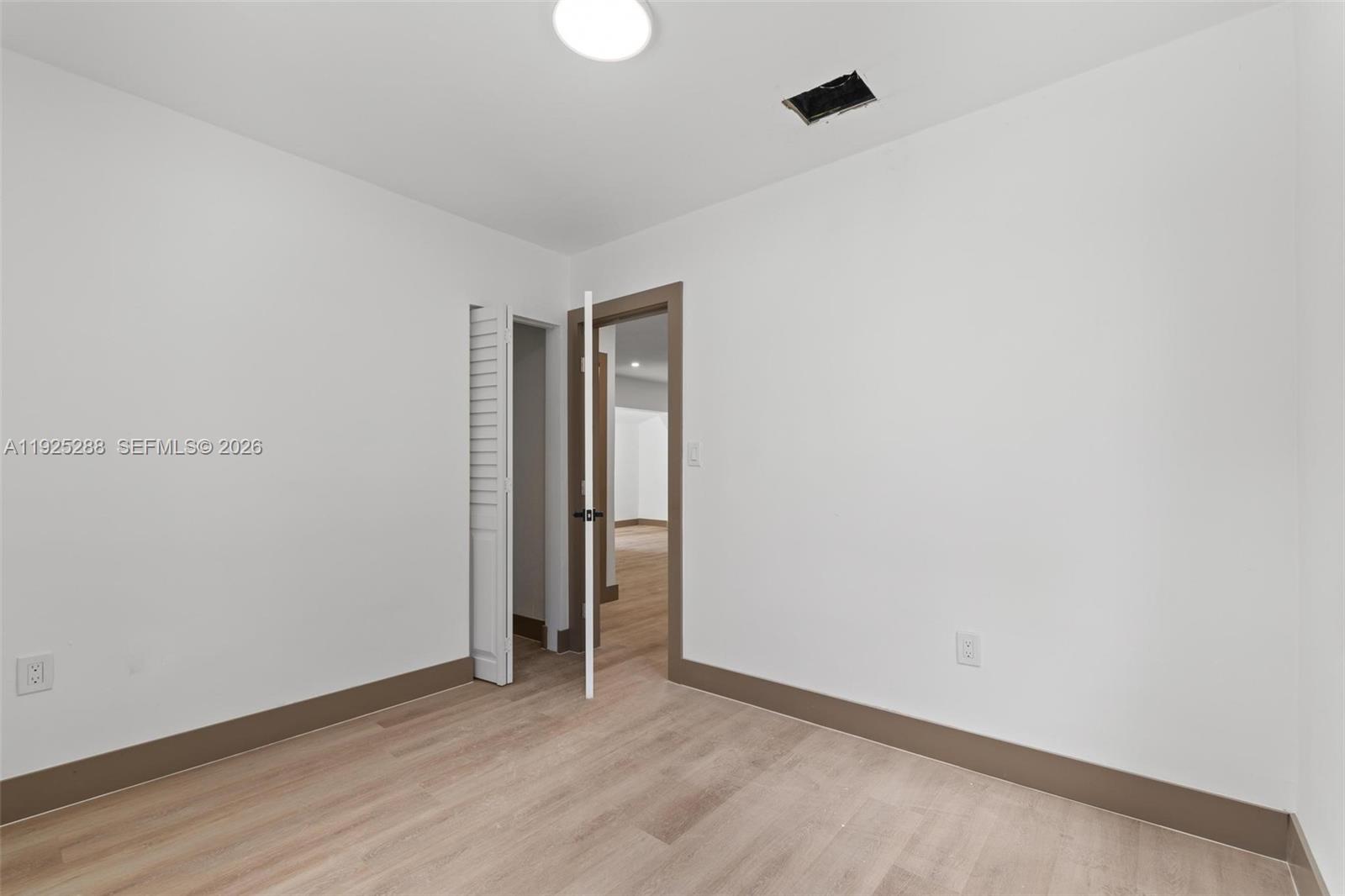 1453 Northwest 56th Street Miami, FL 33142 - Photo 13 of 29 a view of an empty room with wooden floor and closet