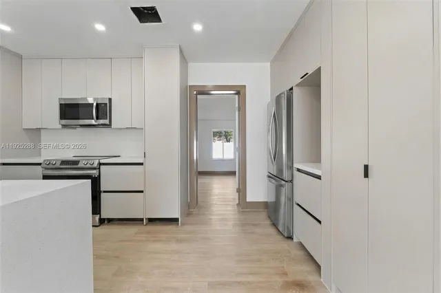 a kitchen with stainless steel appliances a refrigerator stove and microwave