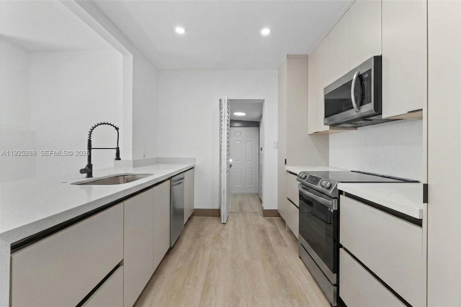 1453 Northwest 56th Street Miami, FL 33142 - Photo 5 of 29 a kitchen with stainless steel appliances granite countertop a sink stove and refrigerator