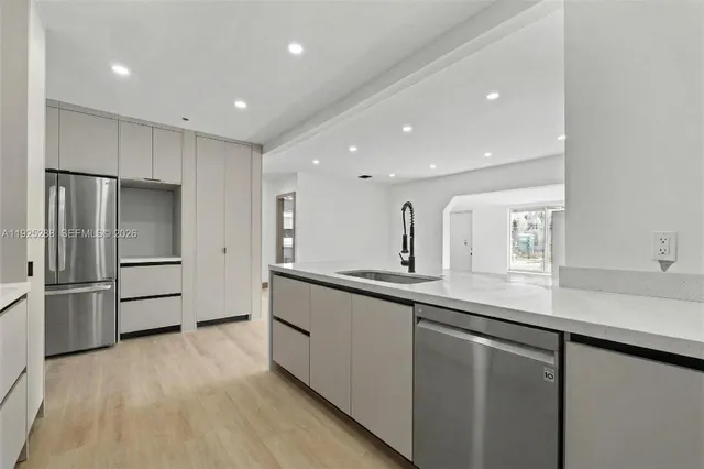 a kitchen with stainless steel appliances granite countertop a refrigerator and a sink