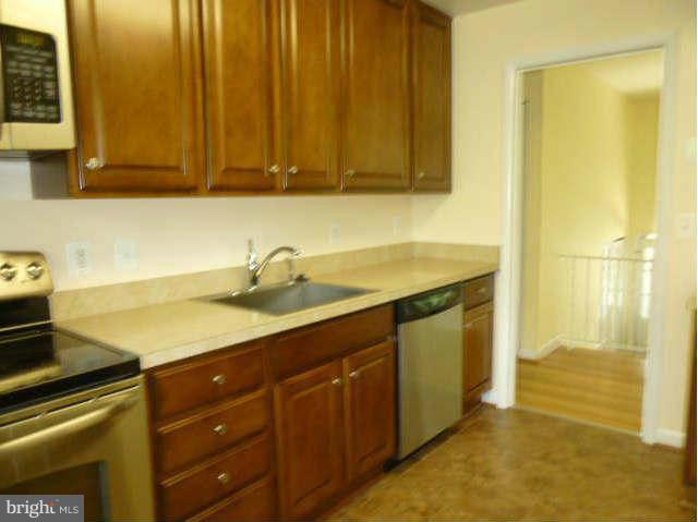 2225 Forest Glen Road Silver Spring, MD 20910 - Photo 11 of 30 a kitchen with stainless steel appliances granite countertop a sink and cabinets
