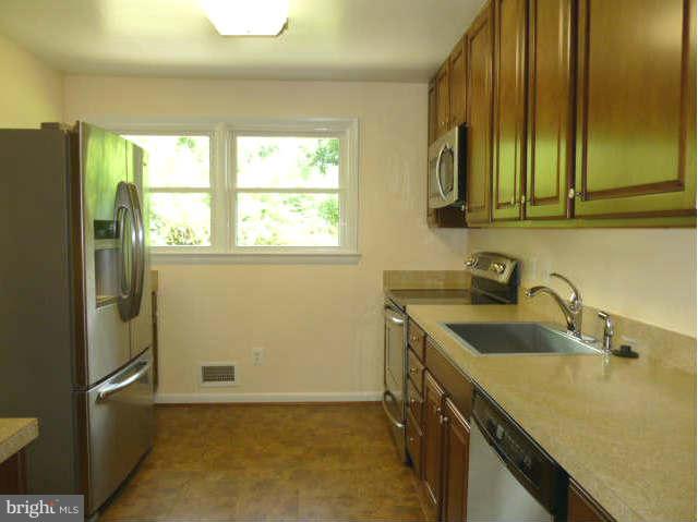 2225 Forest Glen Road Silver Spring, MD 20910 - Photo 9 of 30 a kitchen with a sink a refrigerator and cabinets