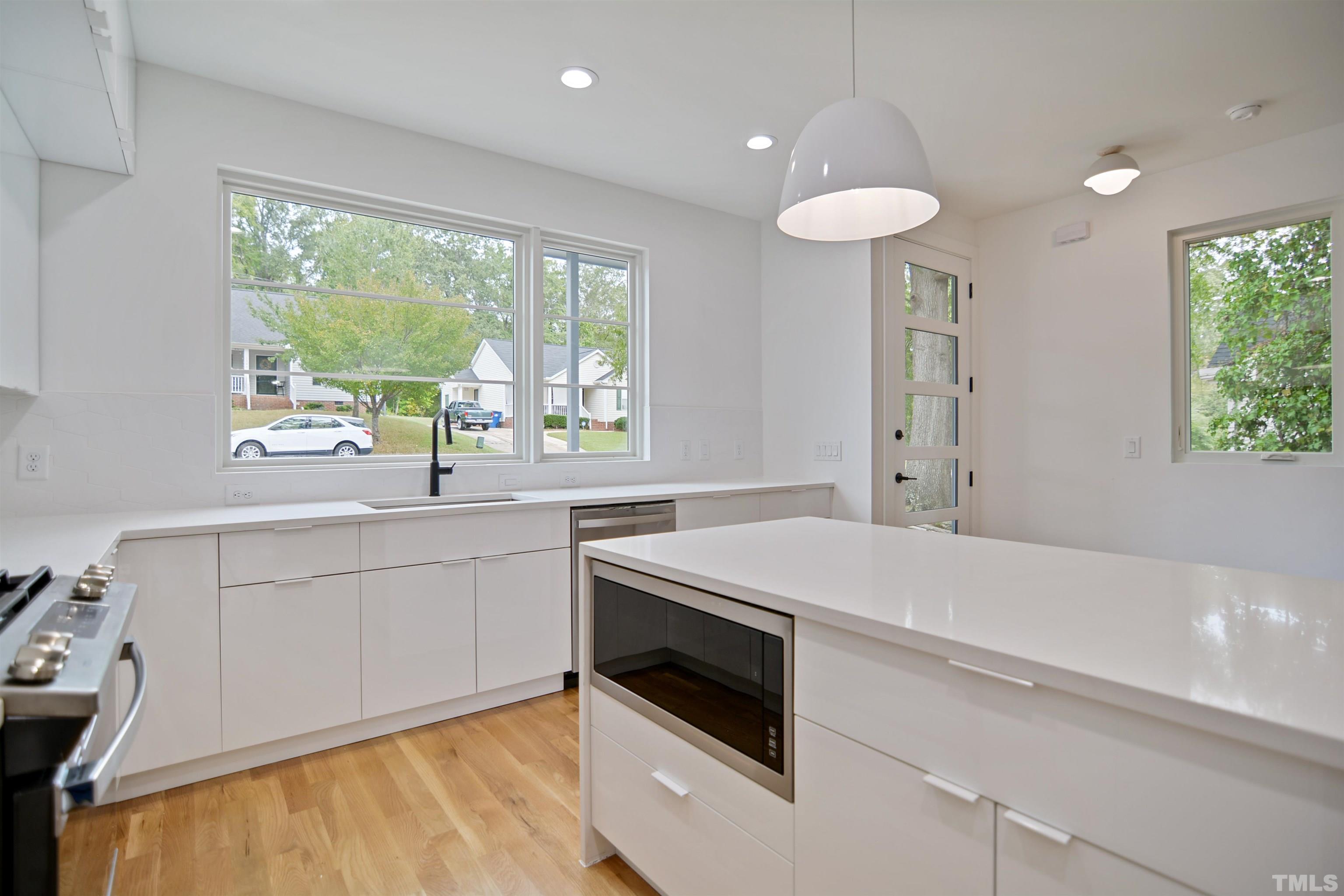1306 East Lenoir Street Raleigh, NC 27610 - Photo 11 of 26 a kitchen with a stove a sink and a refrigerator