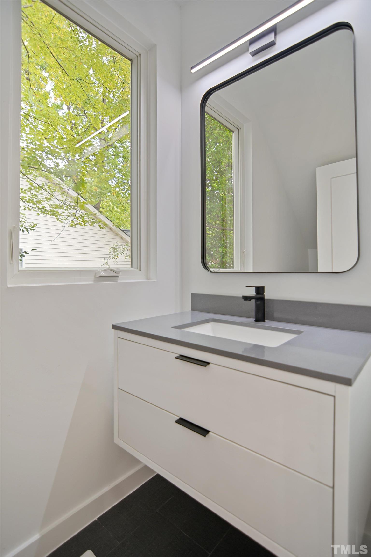 1306 East Lenoir Street Raleigh, NC 27610 - Photo 12 of 26 a bathroom with a sink and a mirror