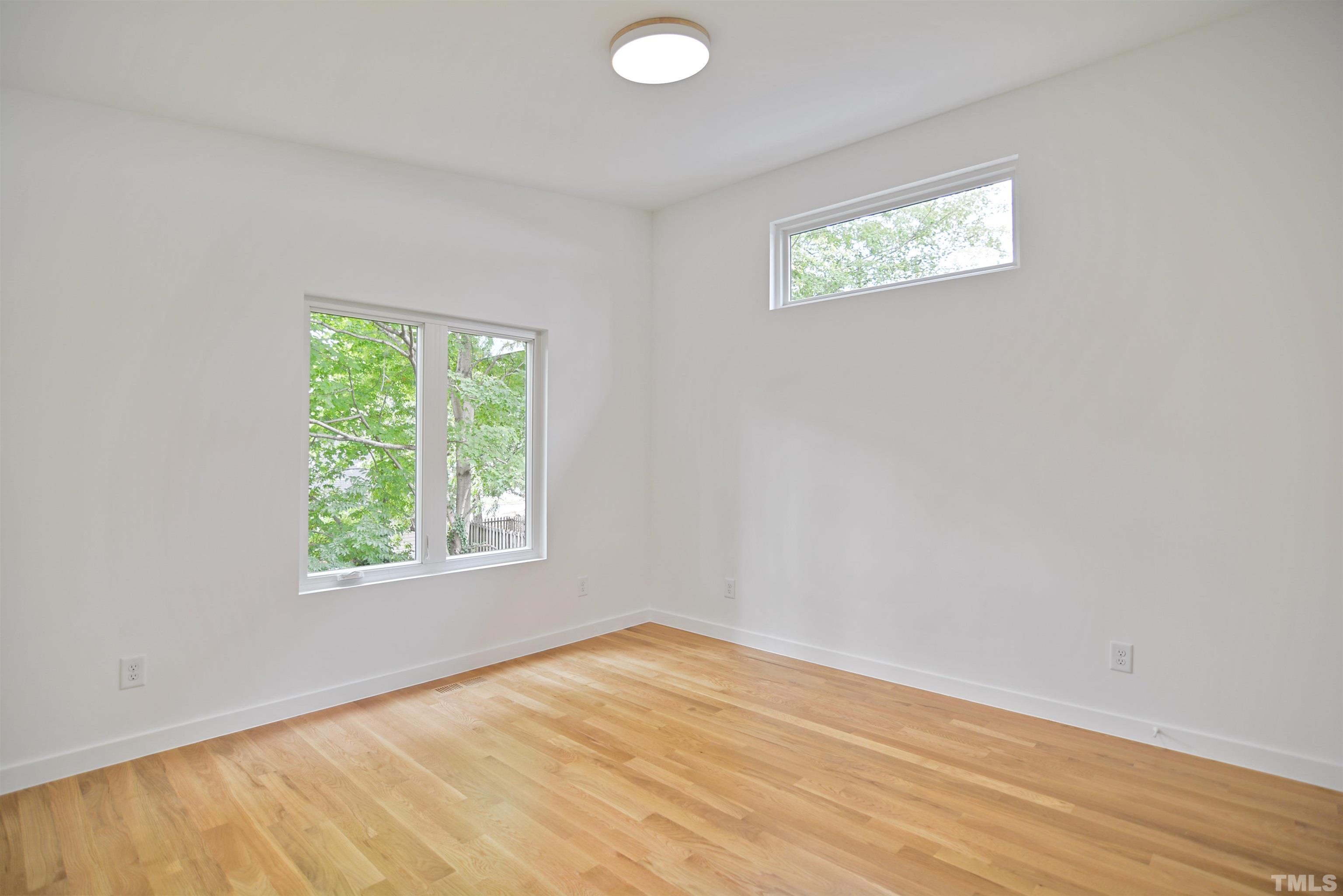 1306 East Lenoir Street Raleigh, NC 27610 - Photo 17 of 26 an empty room with wooden floor and windows