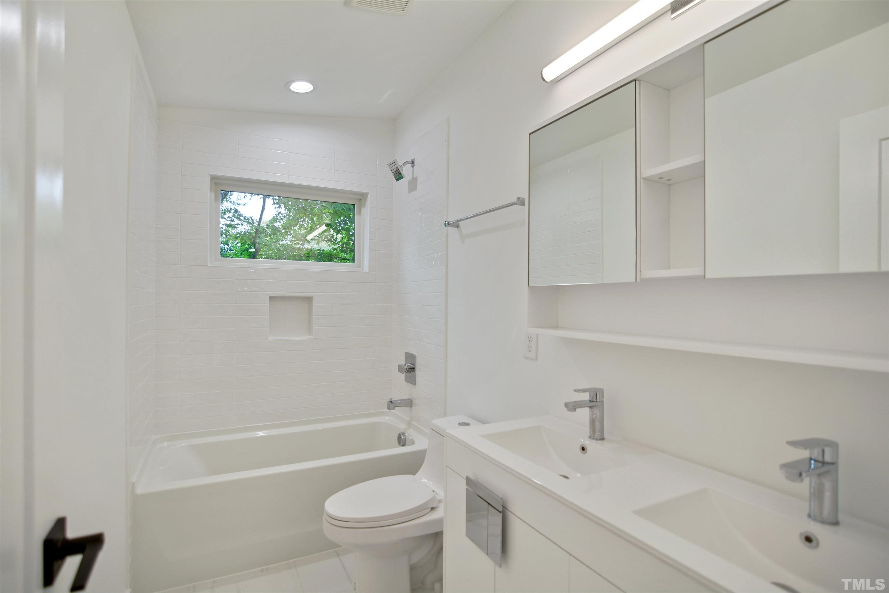 1306 East Lenoir Street Raleigh, NC 27610 - Photo 21 of 26 a bathroom with a sink a toilet and a bathtub