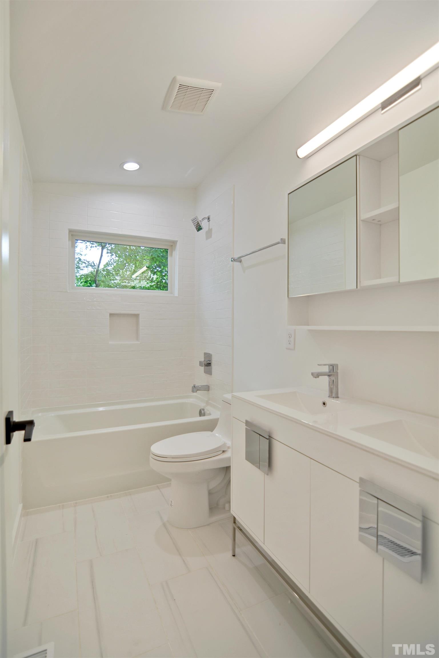 1306 East Lenoir Street Raleigh, NC 27610 - Photo 22 of 26 a bathroom with a toilet a sink a tub and mirror