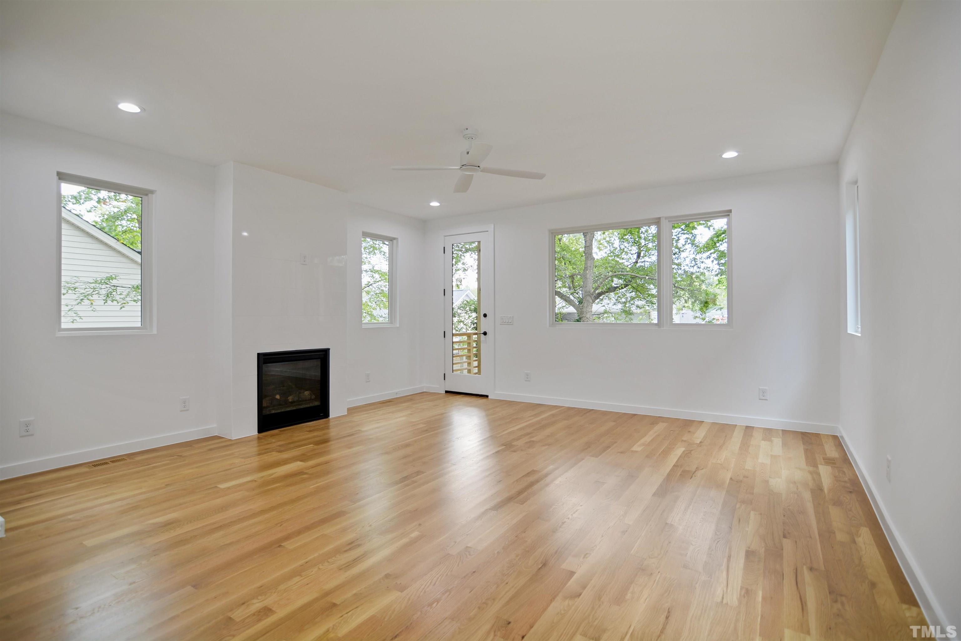 1306 East Lenoir Street Raleigh, NC 27610 - Photo 4 of 26 a view of an empty room with wooden floor and a window