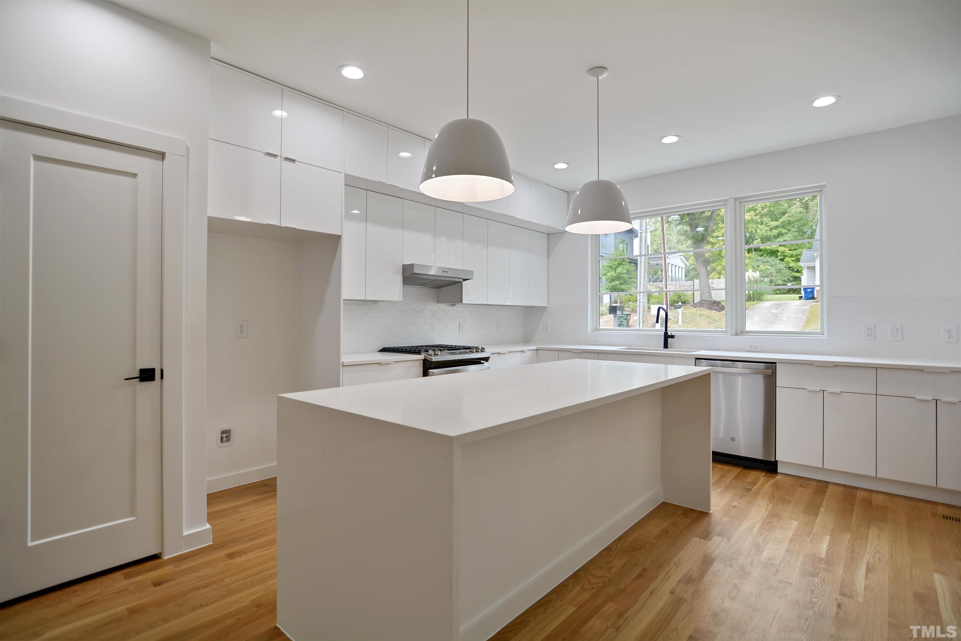 1306 East Lenoir Street Raleigh, NC 27610 - Photo 9 of 26 a kitchen with a stove a sink and wooden floor
