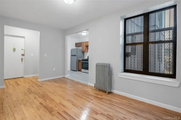 a view of an empty room with cabinet and a window