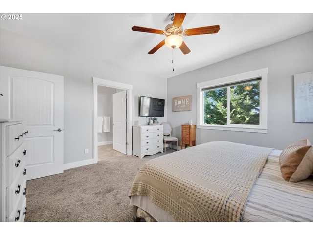 a bedroom with a large bed a flat tv screen and dresser