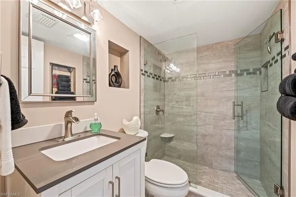 a bathroom with a sink a toilet and shower