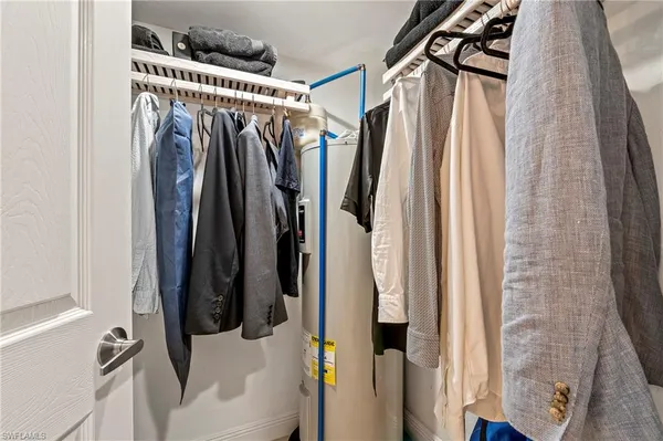 a view of walk in closet with clothes and shoes
