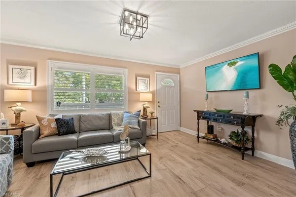 a living room with furniture and a flat screen tv with wooden floor