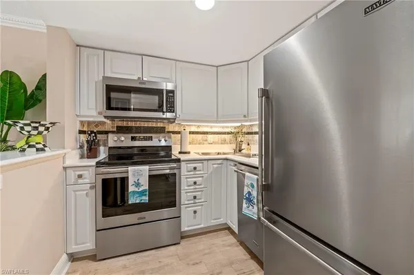 a kitchen with stainless steel appliances a stove microwave and sink
