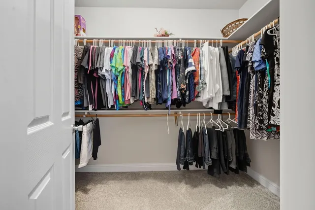a view of walk in closet with clothes